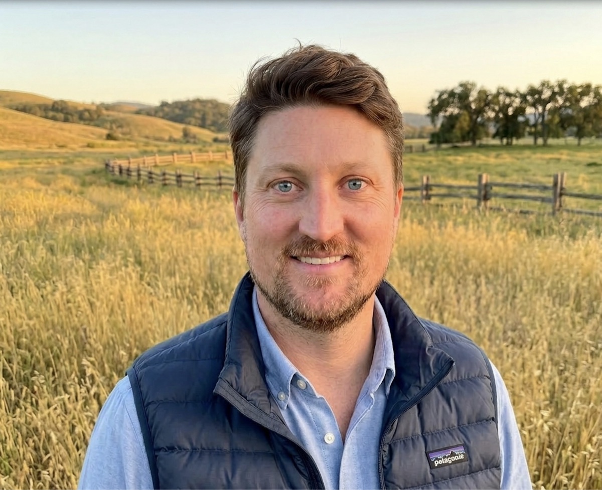 John Coppinger outdoors in a field at sunset.